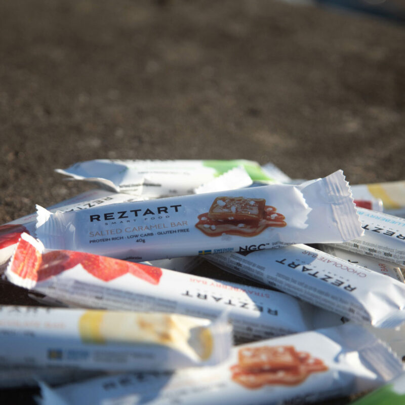 Reztart proteinbars i olika smaker ligger i en hög på en bergshäll.